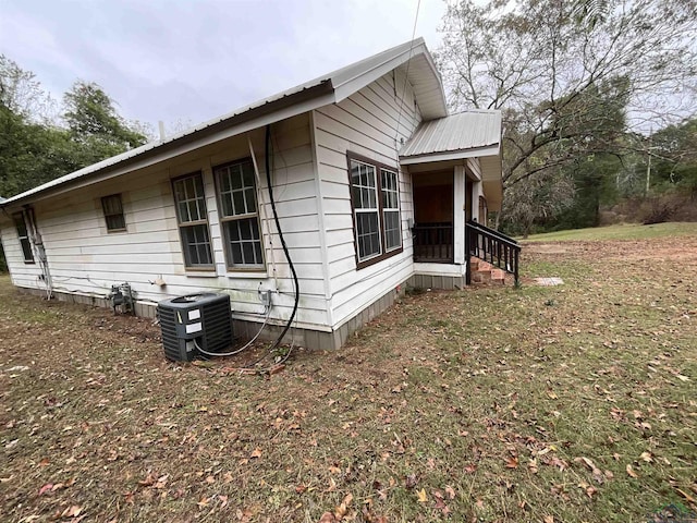 view of side of home with cooling unit and a yard