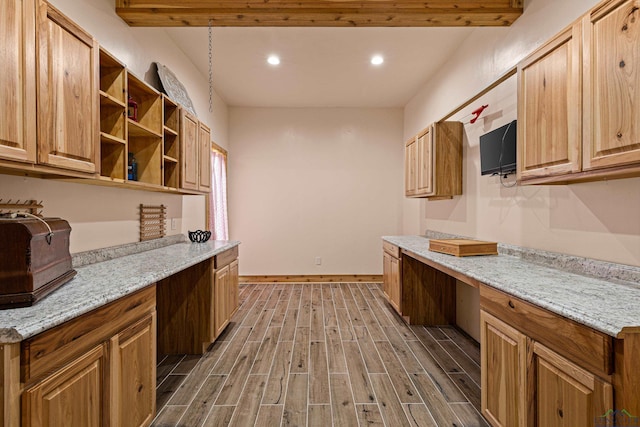 kitchen featuring built in desk and light stone countertops