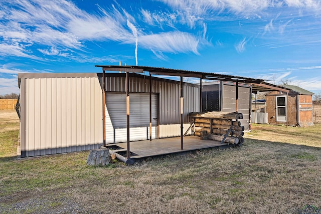 back of house with a yard and an outdoor structure