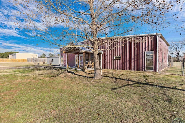 back of house featuring a lawn and an outbuilding