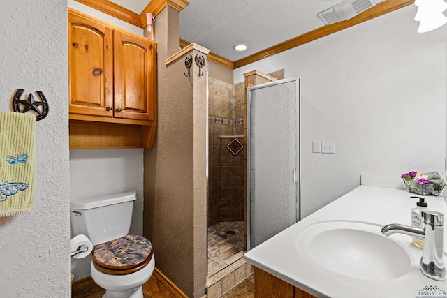 bathroom with toilet, tiled shower, a textured ceiling, and ornamental molding