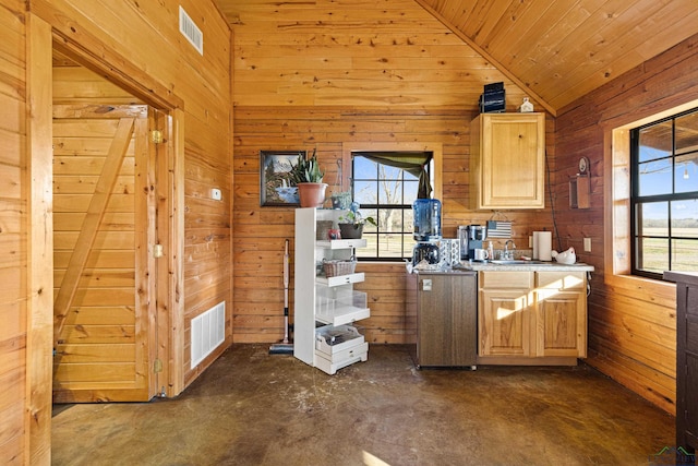 kitchen with wood walls, light brown cabinets, lofted ceiling, wooden ceiling, and sink