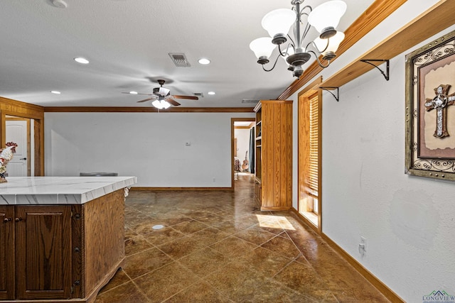 kitchen featuring ceiling fan with notable chandelier, tile counters, and ornamental molding