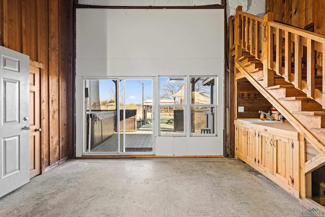 unfurnished living room featuring sink and a towering ceiling