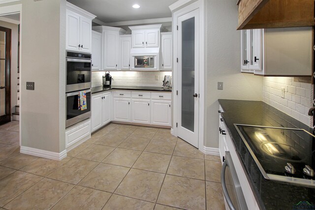 24130 Stallion Park Pl, Lindale, TX 75771 - kitchen with tasteful backsplash, light tile patterned floors, dark countertops, and stainless steel appliances