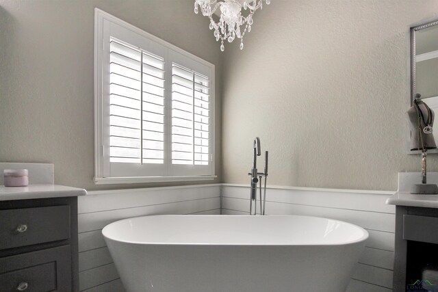 24130 Stallion Park Pl, Lindale, TX 75771 - full bath with a freestanding bath, vanity, a notable chandelier, and wainscoting