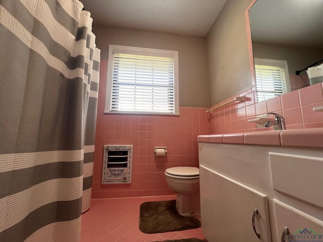 bathroom with tile patterned flooring, plenty of natural light, tile walls, and heating unit