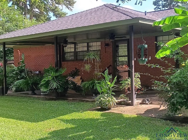 exterior space featuring ceiling fan and a yard