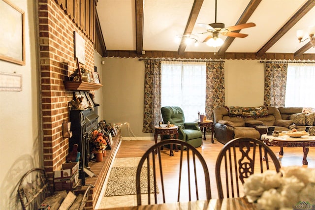 920 Deer Cove Rd, Avinger, TX 75630 - dining space with ceiling fan, beamed ceiling, light wood-style flooring, and a fireplace