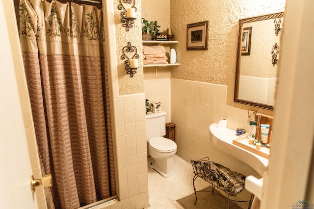 bathroom with tile patterned floors, curtained shower, tile walls, and toilet