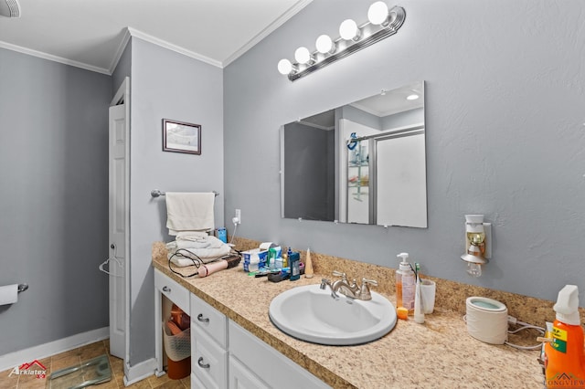 bathroom featuring vanity, ornamental molding, baseboards, and a stall shower