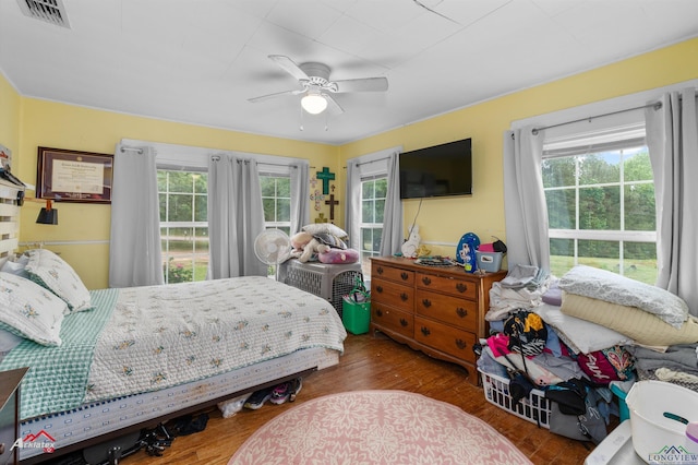 bedroom featuring ceiling fan, visible vents, and wood finished floors