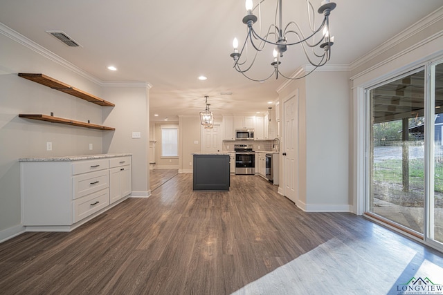 kitchen with stainless steel appliances, crown molding, dark hardwood / wood-style floors, white cabinetry, and hanging light fixtures