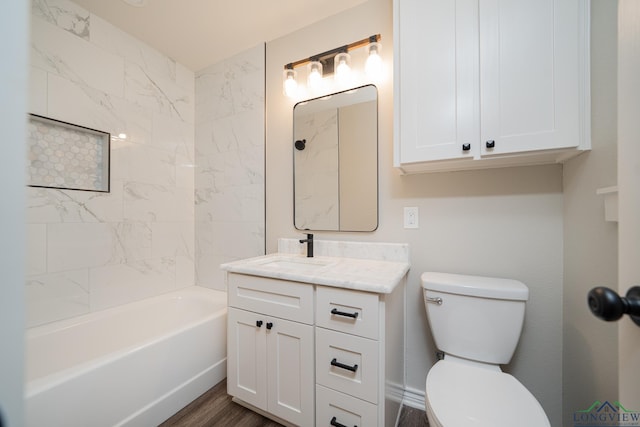 full bathroom featuring hardwood / wood-style floors, vanity, toilet, and tiled shower / bath