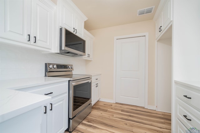 3603 Stracener Rd, Longview, TX 75605 - kitchen with stainless steel appliances, backsplash, light wood-type flooring, light countertops, and white cabinetry