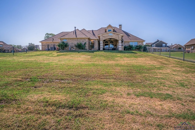 111 Winifreds Way, Hallsville, TX 75650 - view of front of house with stone siding, a fenced backyard, a front lawn, and a chimney