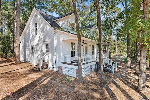 view of side of property with ceiling fan and covered porch