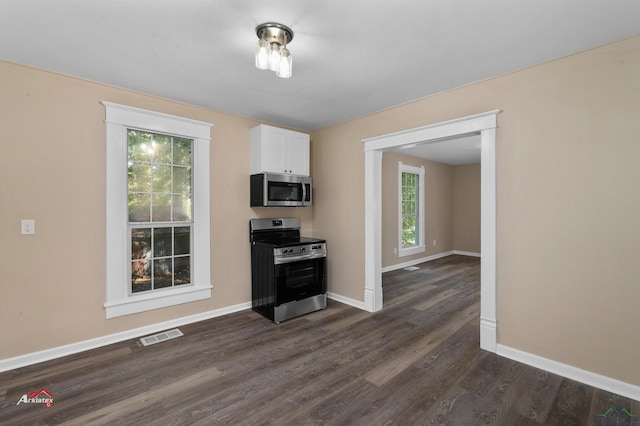 kitchen featuring white cabinets, dark hardwood / wood-style floors, a healthy amount of sunlight, and stainless steel appliances