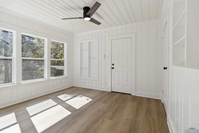 unfurnished sunroom with ceiling fan