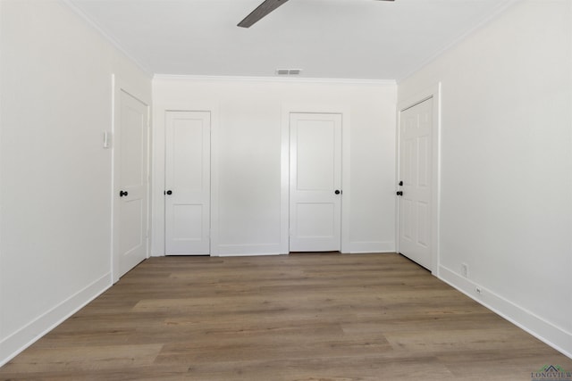 unfurnished bedroom with ceiling fan, light wood-type flooring, and ornamental molding