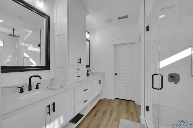 bathroom featuring vanity, hardwood / wood-style floors, and walk in shower