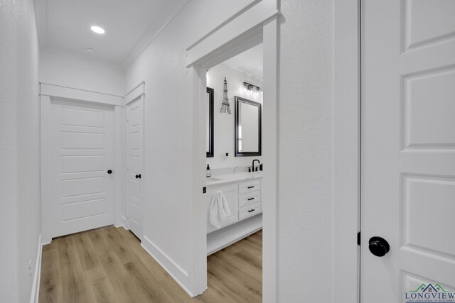 hall featuring ornamental molding and light hardwood / wood-style flooring