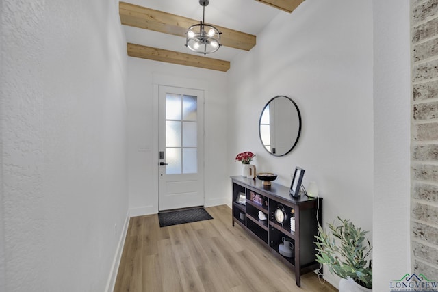 entryway featuring beamed ceiling, a chandelier, and light hardwood / wood-style floors