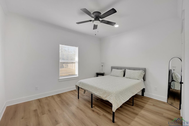 bedroom featuring ornamental molding, ceiling fan, and light wood-type flooring