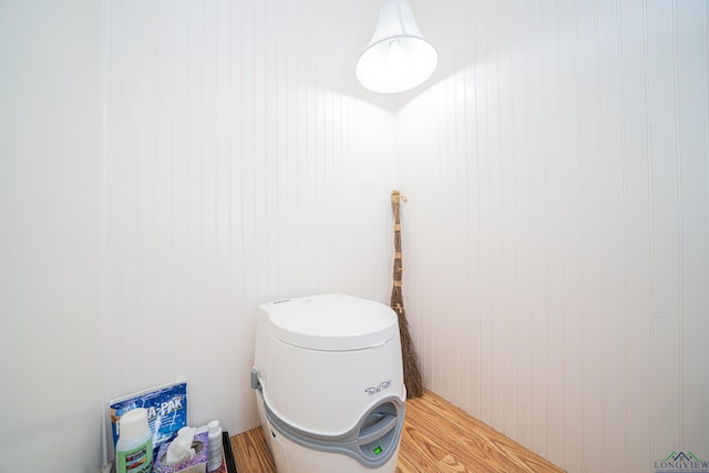 bathroom featuring wooden walls and wood-type flooring