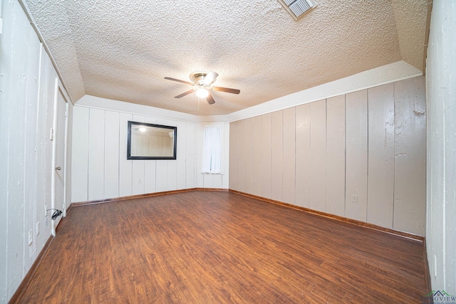 empty room with hardwood / wood-style flooring, ceiling fan, and vaulted ceiling