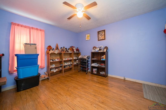 interior space featuring baseboards, a ceiling fan, and wood finished floors