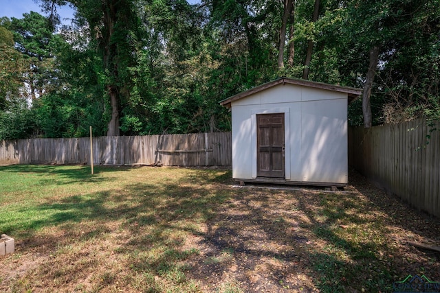 view of yard with an outbuilding, a storage shed, and a fenced backyard