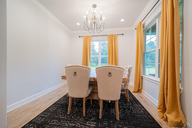 dining area featuring a notable chandelier, light hardwood / wood-style floors, and ornamental molding