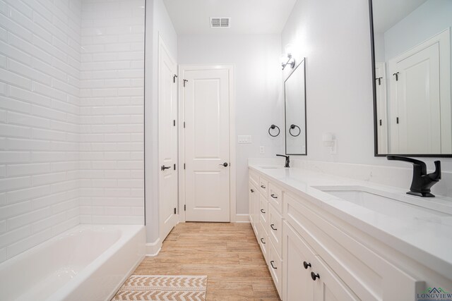 bathroom featuring vanity, wood-type flooring, and tub / shower combination