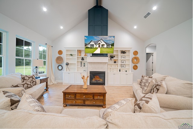 living room featuring high vaulted ceiling and light wood-type flooring