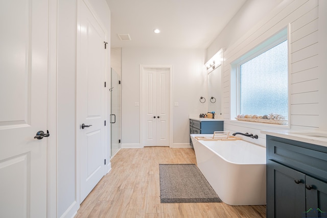 bathroom with vanity, hardwood / wood-style flooring, and separate shower and tub