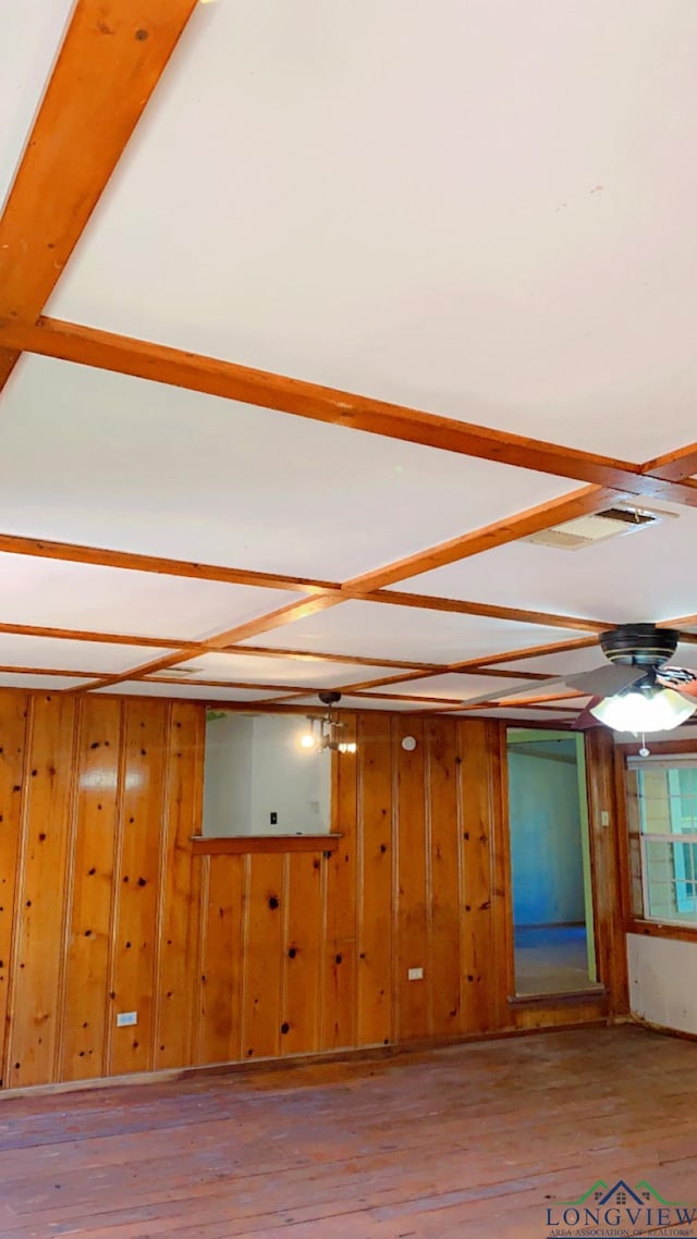 empty room with light hardwood / wood-style floors and wood walls