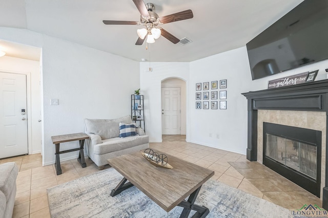 living room with a fireplace, light tile patterned floors, and ceiling fan