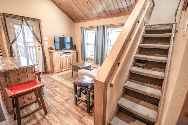 stairway featuring wood ceiling, wood-type flooring, and lofted ceiling