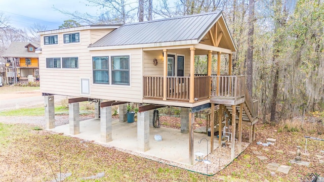 rear view of property featuring covered porch