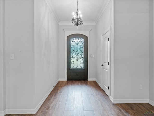 foyer featuring hardwood / wood-style flooring, crown molding, and an inviting chandelier