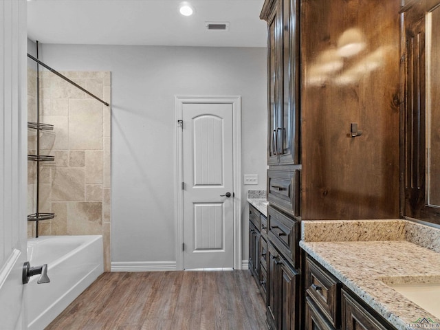 bathroom featuring shower / bathing tub combination, wood-type flooring, and vanity