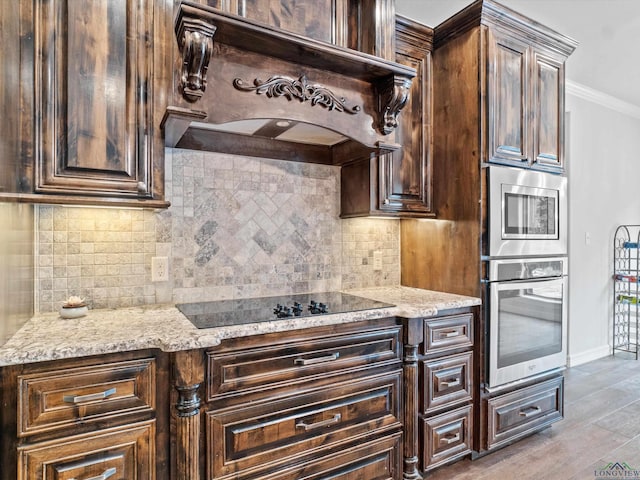 kitchen with light wood-type flooring, premium range hood, ornamental molding, dark brown cabinets, and stainless steel appliances