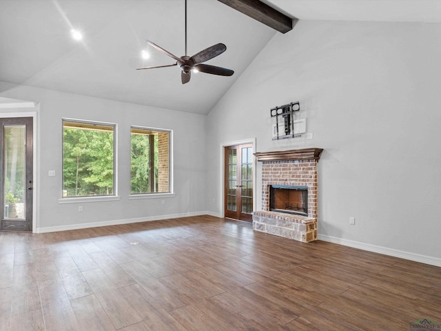 unfurnished living room with ceiling fan, a brick fireplace, beamed ceiling, high vaulted ceiling, and wood-type flooring