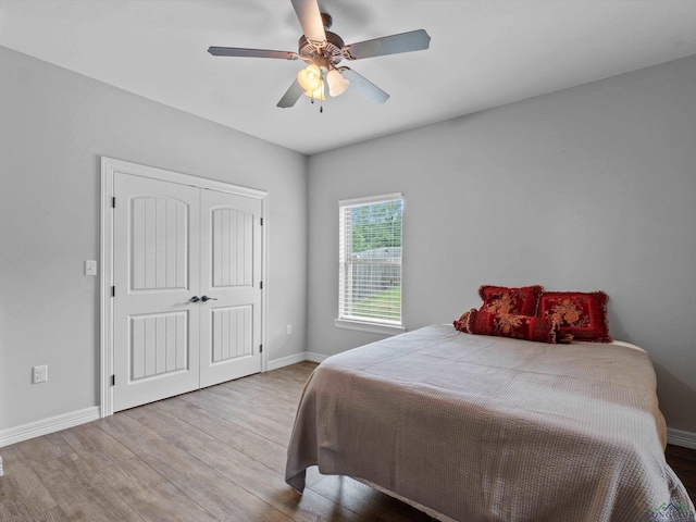 bedroom featuring ceiling fan, a closet, and light wood-type flooring