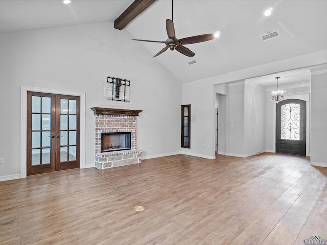 unfurnished living room with high vaulted ceiling, french doors, ceiling fan with notable chandelier, light hardwood / wood-style flooring, and beam ceiling