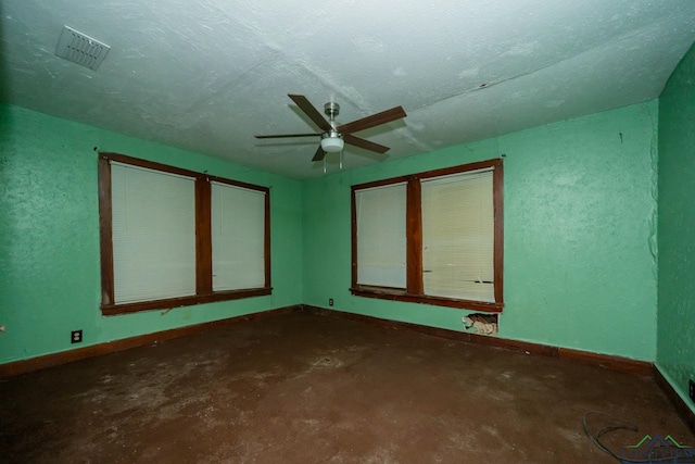 empty room featuring ceiling fan, a textured ceiling, and concrete floors