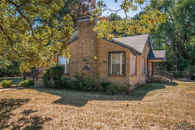 view of side of home with a lawn