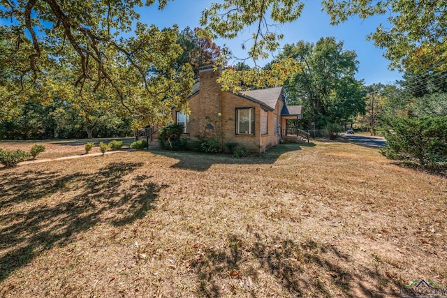 view of side of home with a lawn