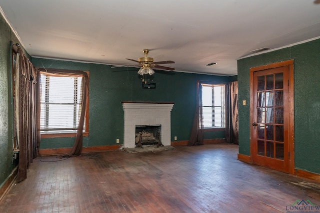 unfurnished living room featuring hardwood / wood-style flooring, ceiling fan, ornamental molding, and a fireplace